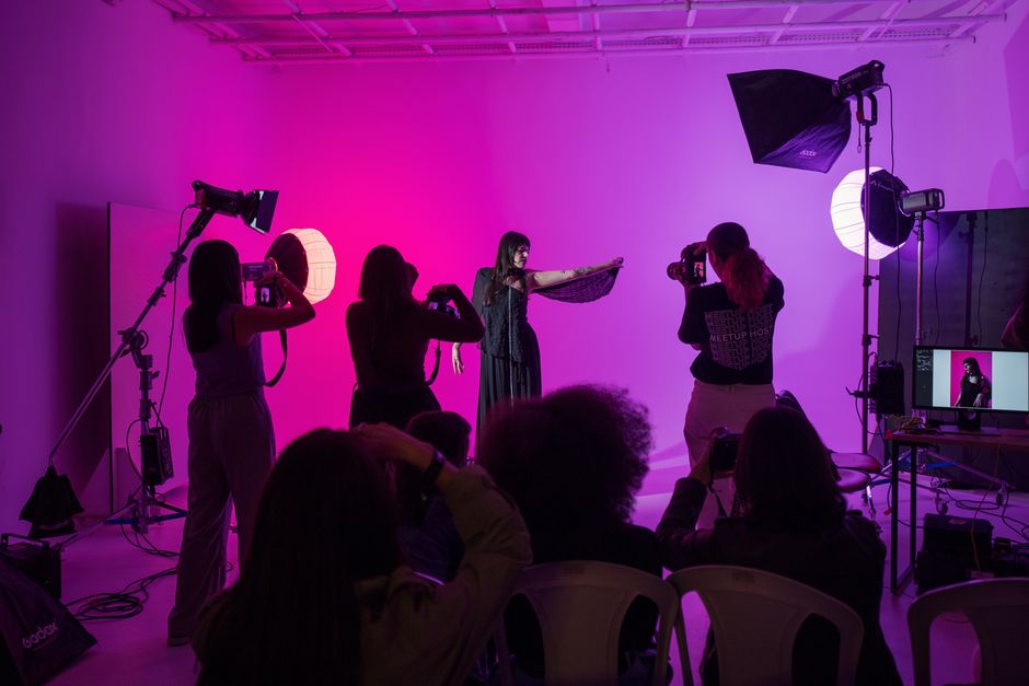 Capture of a live photography workshop with vibrant studio lighting and active participants.
