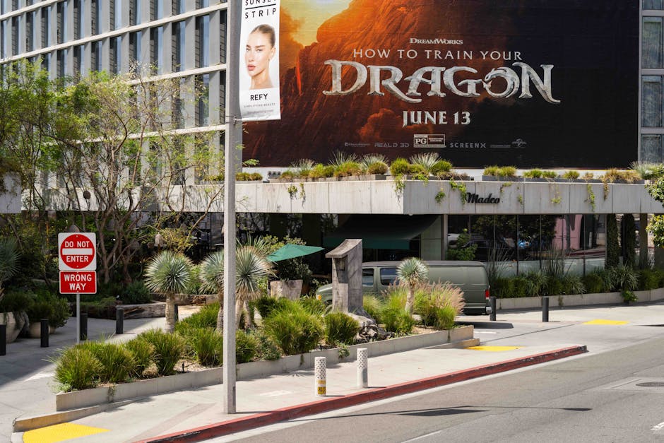 Daytime street view of Madeo restaurant with greenery and large billboard in Los Angeles.
