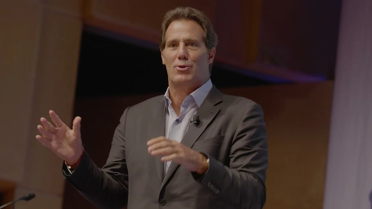Sponsor speaking on camera at a summit